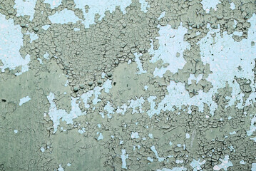 Fototapeta premium Peeling paint on old wall. Cracked surface with layered green and blue colors, grunge texture for vintage background and design.