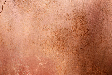 Fototapeta premium Aged metallic wall with pearlescent coating, corrosion marks and uneven worn paint, abstract industrial background in warm tones.