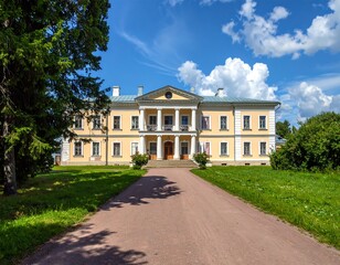 Obraz premium A large, yellow, multi-story building with a long driveway