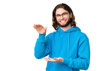Fototapeta premium Young handsome man over isolated chroma key background holding copyspace to insert an ad