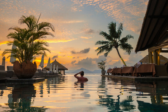 Relaxing in luxury by the serene infinity pool during a stunning Seychelles sunset