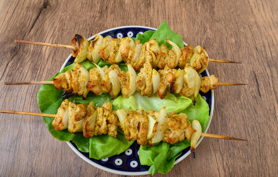 Delicious chicken and pork skewers with grilled onions