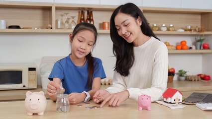 Mother teaching daughter about saving money
