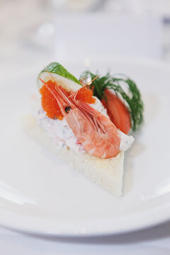 Classic Swedish Toast Skagen appetizer featuring creamy prawn salad on toasted bread, topped with fresh shrimp, red bleak roe, a lime wedge, and dill. Elegant seafood starter for gourmet dining.