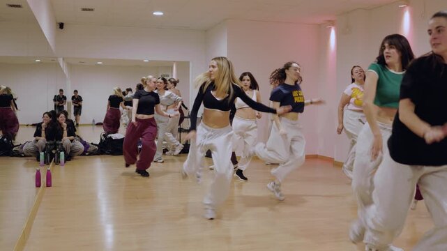 Energetic dance class learning choreography in studio