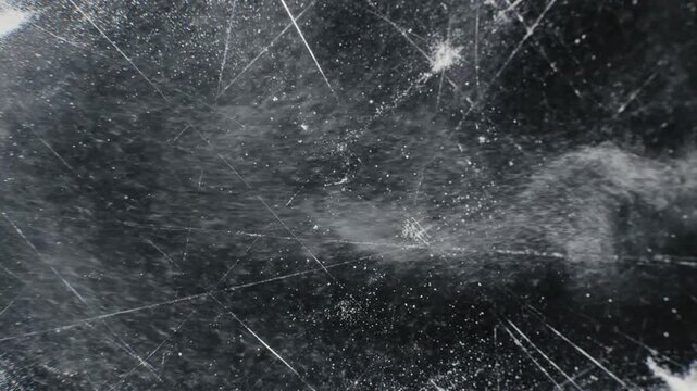 Abstract grunge distressed overlay texture with rough worn grain and scratched noise pattern design. Grungy urban stained speckled dappled gritty background for vintage cinematic video effects.