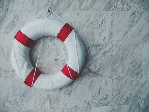 Lifebuoy ring on marble wall, safety and rescue symbol for emergency aid and nautical transport