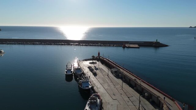 Drone flying over javea port pier in spain at sunrise
