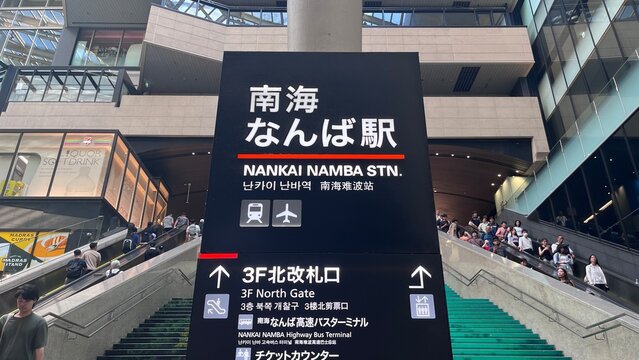 Nankai Namba Station entrance signage directing to 3F North Gate and Yucho Bank (Japan Post Bank) ATMs with commuters on escalators - Osaka, Japan, August 31, 2025