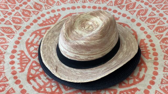 Sombrero de paja beige girando 360&deg; sobre toalla de playa