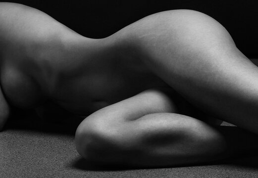 Naked woman Yoga on black background. Fine art photo of female body.	