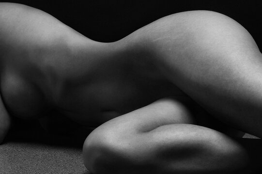 Naked woman Yoga on black background. Fine art photo of female body.	