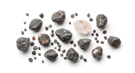 Obraz premium Assortment of raw natural gemstones and small dark pebbles scattered on a white background.