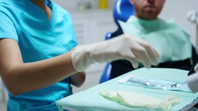 Female dentist or nurse wearing surgical gloves preparing for a patient examination in a clinic