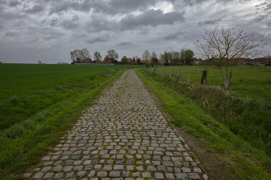 route en pav&eacute; emprunt&eacute; par la course cycliste du paris Roubaix secteur  Templeuve moulin  avec   un ciel gris mena&ccedil;ant 
