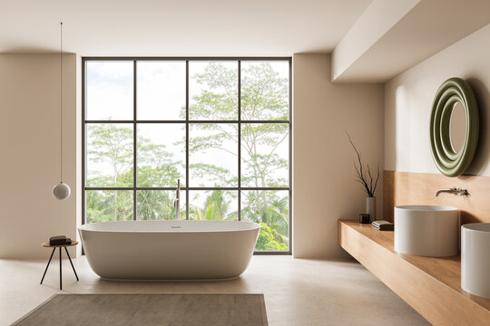 Serene modern bathroom interior featuring freestanding tub, panoramic window view of lush greenery, minimalist fixtures and soft neutral palette. 3D Rendering