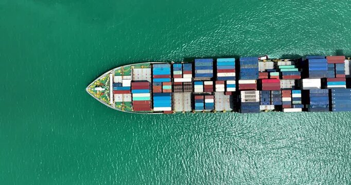 Large Cargo Ship Carrying Colorful Containers Across The Tropical Sea