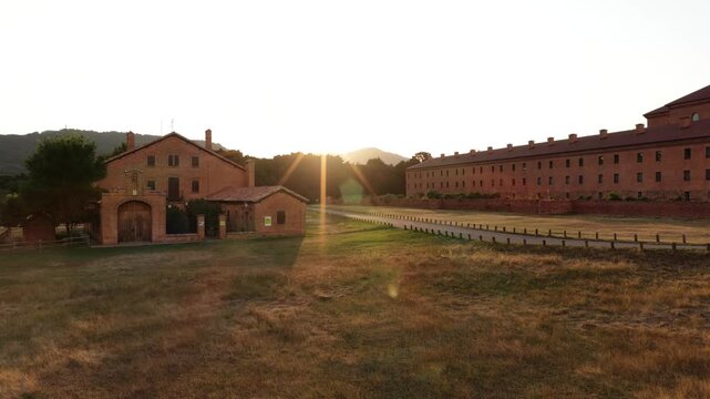Beautiful aerial shot revealing the historic Mon Sant Benet monastery in Catalonia, Spain, during a warm and golden sunset hour