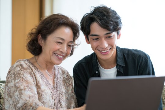 ノートパソコンを見る祖母と孫