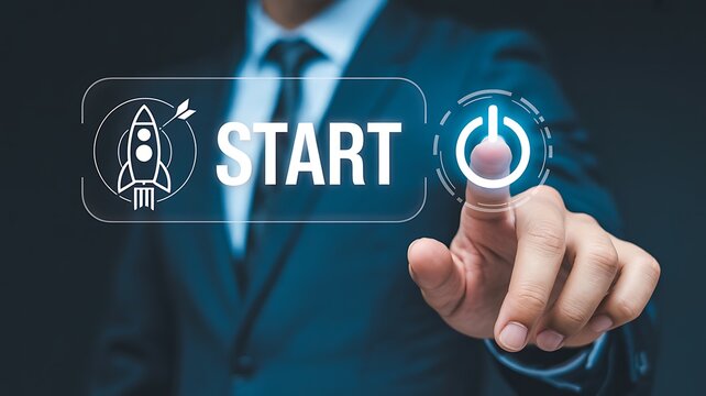 A businessman in a suit activates a glowing start button with his index finger in a dark room with futuristic icons.
