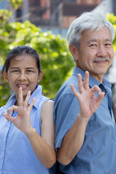 Happy smiling healthy Asian senior couple, old husband and wife showing approving, passing, good, yes, go for it, good to go, correct, okay, double ok hand gesture