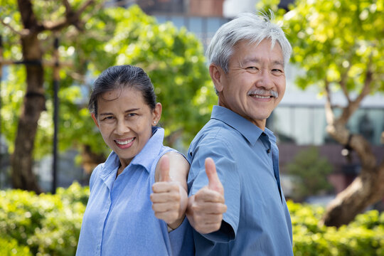 Happy smiling healthy Asian senior couple, old husband and wife showing approving, passing, good, yes, go for it, good to go, two thumbs up or double thumbs up hand gesture