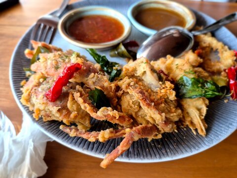 Deep-fried soft shell crab served with dipping sauces and chili, crispy seafood dish with rich texture and vibrant colors