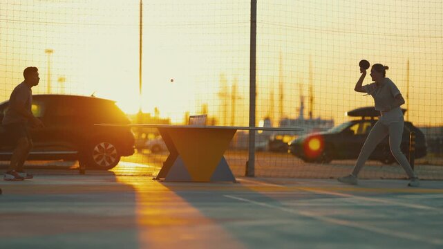 Woman playing table tennis at sunset