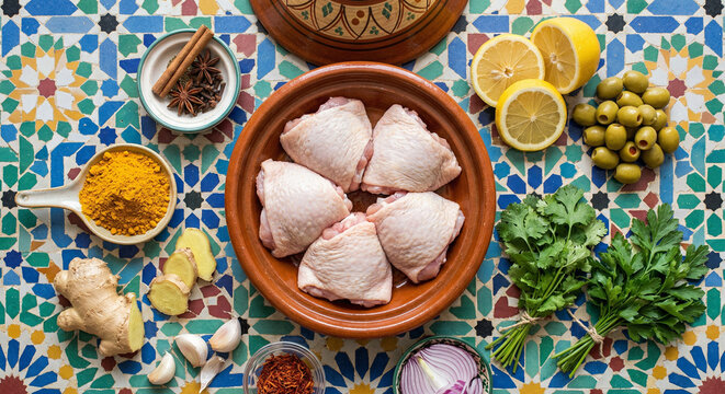Overhead flat lay of Moroccan Tagine ingredients on intricate zellige tiles