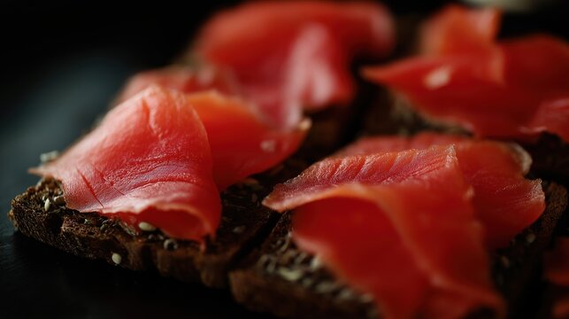 tonalite. Close-up of oily smoked salmon slices on dark rye bread. menu design, packaging mockups, designed for culinary blogs and recipe cards for restaurants, used by interior designers.
