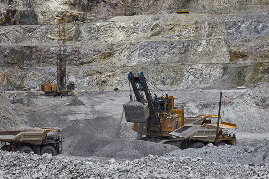 Large electric hydracrowd shovel loading an ultra-class haul truck in an open-pit mining operation, illustrating best practices in synchronized fleet management, operator awareness,