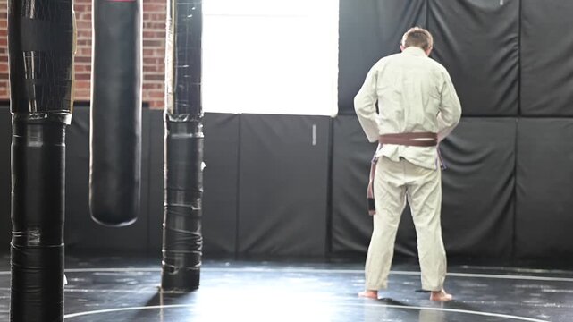 Martial arts tying kimono Gi jiujitsu karate brown belt, traditional, belt, blurred out background video, selective focus cinematic, gym setting