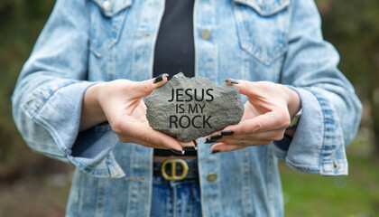 Obraz premium Female hand showing Jesus Is My Rock message on rock.
