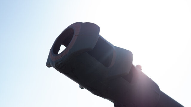 Backlit Tank Barrel Silhouette With Sun Flare, Dramatic Shadowing And Bright Rim Light, Decommissioned Armor Mood, Reflective Highlights And Solemn Tone