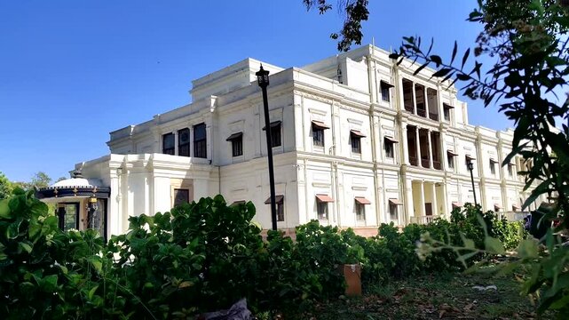 Lal Bagh Palace Indore revealed through garden greenery, Madhya Pradesh, India - A cinematic reveal of the historic Lal Bagh Palace in Indore, showing the grand 19th-century European-style architectur
