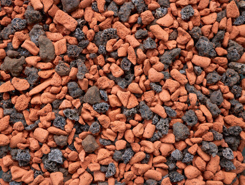 Close‑up of porous horticultural stones forming a textured yellow‑and‑black background, used as a natural substrate and botanical backdrop for plant‑related designs.