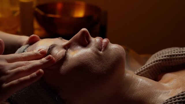 Relaxing facial massage therapy in warm ambient spa setting with gentle skincare treatment, soothing touch, and peaceful relaxation on a comfortable treatment bed