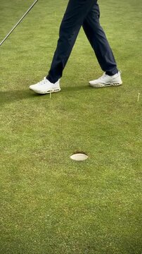 golfer putting the ball into the hole