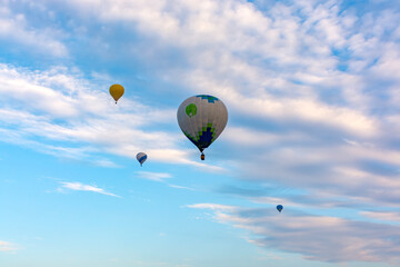Naklejka premium Colorful Hot Air Balloons Soaring in Blue Cloudy Sky at Dawn