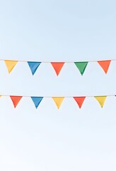 Obraz premium Colorful triangular flags on a string against blue sky background