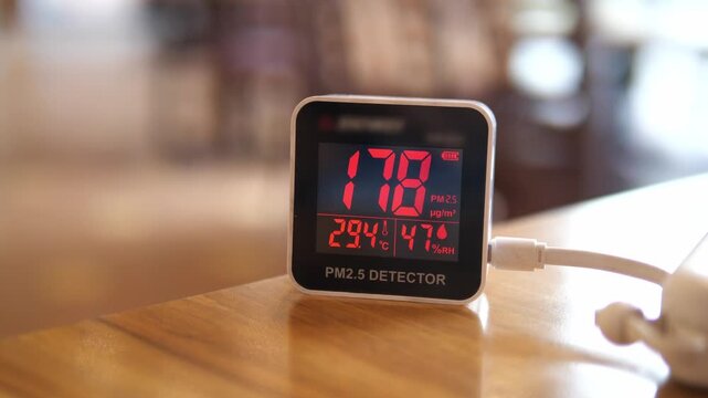 Digital air quality detector showing high hazardous PM 2.5 levels with red warning display for pollution and health concept