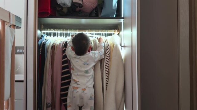 Curious Little Asian Boy Exploring and Messing Around in Mother's Wardrobe.