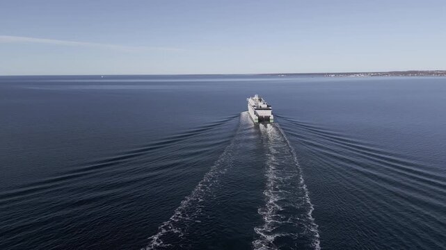 Aerial drone view of passenger ferry sailing across calm Baltic Sea leaving symmetrical wake near Tallinn Estonia