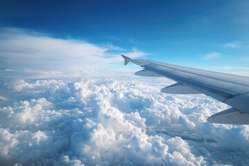 Obraz premium View from Airplane Window Above Fluffy White Clouds on a Sunny Day.