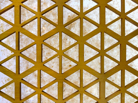 Close up of gold steel metallic laser cut pattern in geometric star shape, with white marble background. Golden paint screens panel and 3D laser cutting shapes. Seamless texture.