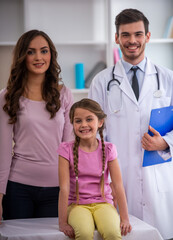 Fototapeta premium Happy child with mother and doctor in clinic.