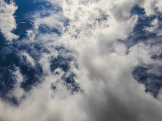 Fototapeta premium Dynamic clouds drift across a vast blue sky in Kyrgyzstan. The atmospheric scene captures the beauty of daylight outdoors, evoking a sense of wonder.
