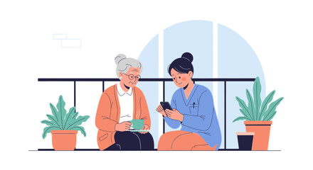 Fototapeta premium Elderly woman and caregiver enjoying coffee and smartphone on balcony