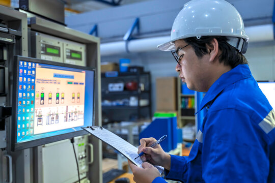 Engineer working at control room In large industrial plants,Manager control system,Technician man monitoring program from a lot of monitor,Concept Industry