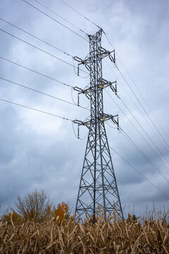 High-voltage power pylons against a cloudy sky. Distribution of electrical power via an overhead wire line.
